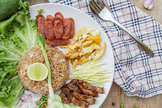 Rice maxed with shrimp paste is Thai Food ingredients are rice, shrimp paste, shallots, chili, fried egg, sweet pork, cucumber, sausage and mango.