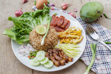 Rice maxed with shrimp paste is Thai Food ingredients are rice, shrimp paste, shallots, chili, fried egg, sweet pork, cucumber, sausage and mango.