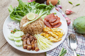 Rice maxed with shrimp paste is Thai Food ingredients are rice, shrimp paste, shallots, chili, fried egg, sweet pork, cucumber, sausage and mango.