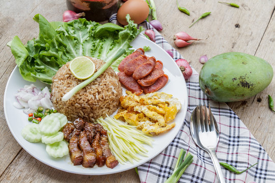 Rice maxed with shrimp paste is Thai Food ingredients are rice, shrimp paste, shallots, chili, fried egg, sweet pork, cucumber, sausage and mango.