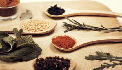 Various spices on kitchen spoons on grunge table
