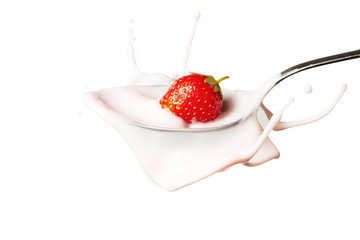 strawberry splashing into the spoon full of yoghurt