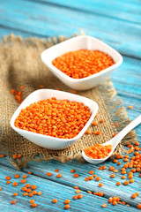 Red lentils in bowl on a blue wooden table
