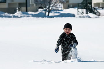 Fototapeta na wymiar Cute boy playing in the snow.