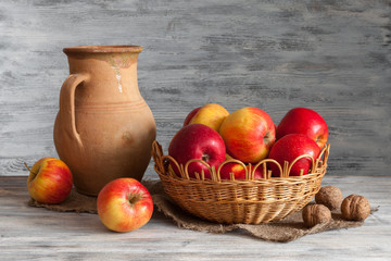 Still life in a rustic style: red apples and an old crock.