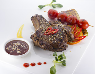 beef steak served with tomatoes and sesame  on a white plate
