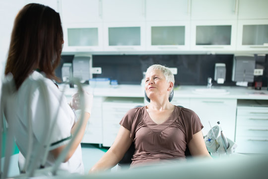 Old Woman Visiting The Dentist Taking Care Of Her Teeth.Dentist Doctor Talking To A Senior Woman Patient.Dental Care For Elder.Prosthodontics And Oral Protesis