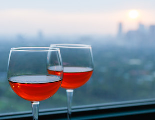 Pair of wine glasses and city view. 