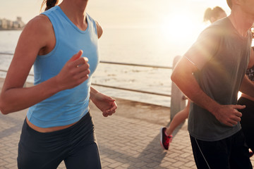 Young people running along seaside