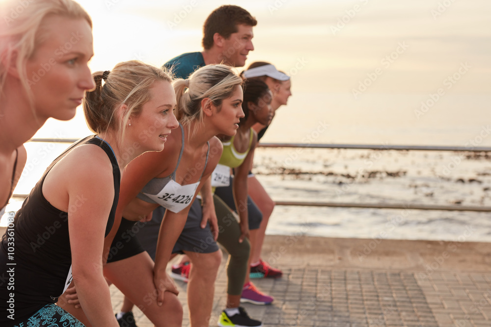 Wall mural Runners on standing at start line of a race