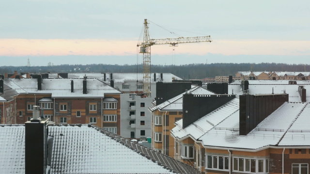 Construction crane works at sunrise in winter