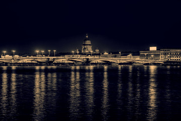 Fototapeta premium Night view of the English embankment, St. Isaac's Cathedral and Annunciation bridge in St. Petersburg, monochrome retro effect