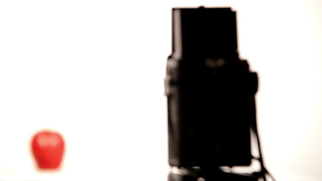 A process of taking picture of an apple with old medium format film camera