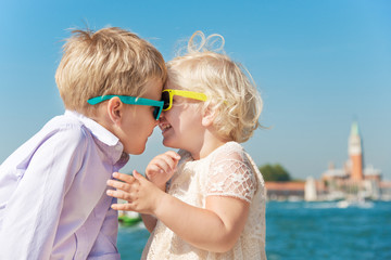 Fototapeta na wymiar Cute little girl and boy wearing sunglasses and playing in Venic
