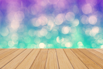 Naklejka na ściany i meble Bamboo wooden top on background of blurred purple, blue and green bokeh - can used for display or montage your products