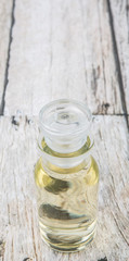 Apple vinegar in glass vial over wooden background
