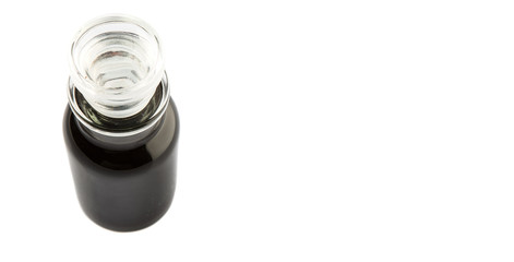 Italian balsamic vinegar in glass vial over wooden background