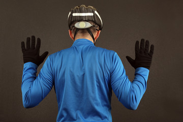 cyclist with arms raised standing with his back