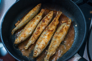 Fried small smelt tasty fish on a barbecue  hotplate