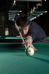 Fototapeta premium Young man playing billiards
