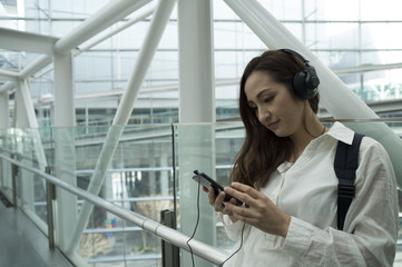 Woman is listening to the music from your phone with a headphone