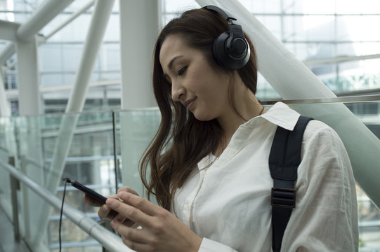 Woman is listening to the music from your phone with a headphone