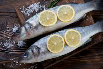 Close-up of fresh uncooked seabass with lemon, high angle view