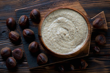 Above view of chestnut cream-soup in a rustic wooden setting