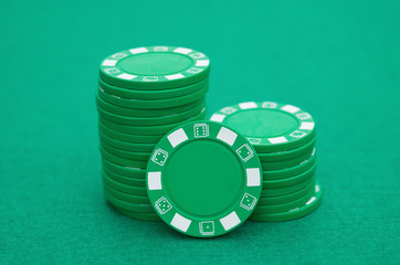lots of green poker chips on casino table