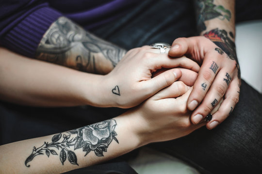 young couple in love, tattoos, cuddling and holding hands