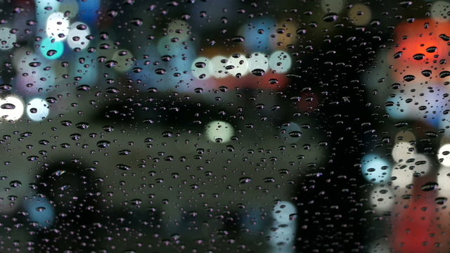 Nightscape of raindrops and defocused commuter traffic.