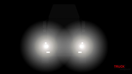 Silhouette of truck with headlights on black background