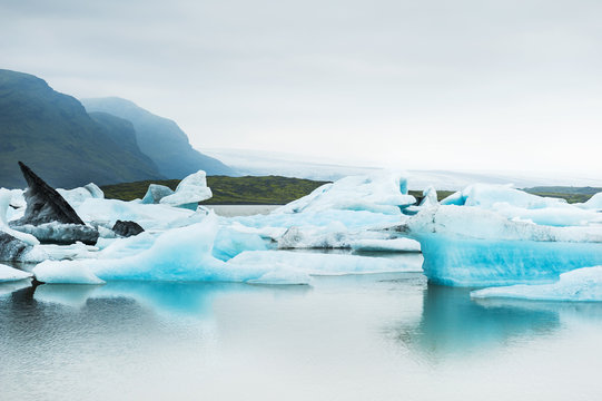 Icebergs in the glacial lake with mountain views.