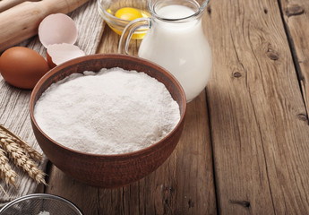 Obraz na płótnie Canvas Flour, egg, milk on wooden table rustic kitchen