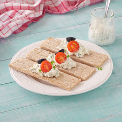 healthy breakfast of dry breads with cheese, tomatoes and olives
