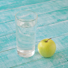 glass of fresh water with a green apple