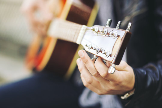 Young attractive street artist with his guitar
