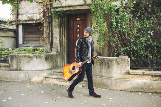 Young attractive street artist with his guitar