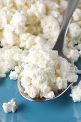 Cottage cheese in spoon close-up