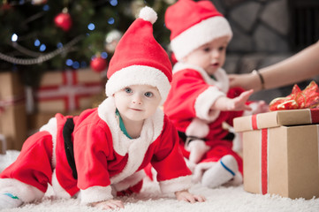 Obraz na płótnie Canvas kids dressed as Santa Claus at Christmas tree with giftsImage ID:168340655