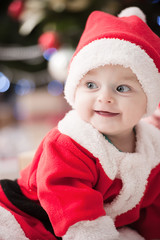 kids dressed as Santa Claus at Christmas tree with gifts