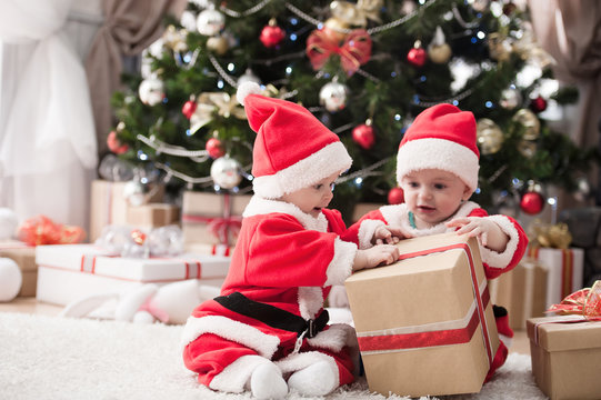 kids dressed as Santa Claus at Christmas tree with gifts

Image ID:168340655