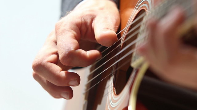 european man plays guitar closeup