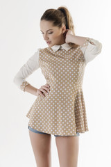 Beautiful blonde girl in a short vest and denim shorts
