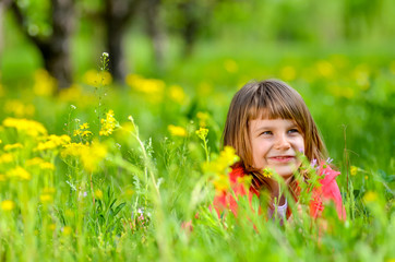 Fototapeta premium little girl lying on the grass in spring
