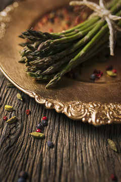 Old dish with green asparagus on an old wood