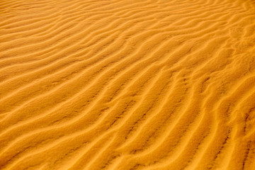 Sand Texture Background. Close up view of orange ripple sand pattern of dunes in desert. Nature elements details. 