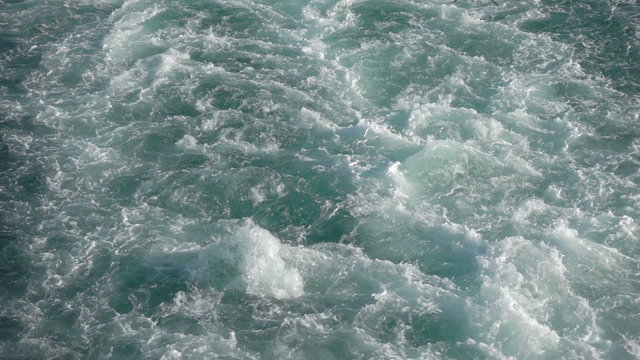 Slow motion sea water splashes at the back of a boat and flying seagulls. Four times slowed down from 100p to 25p.