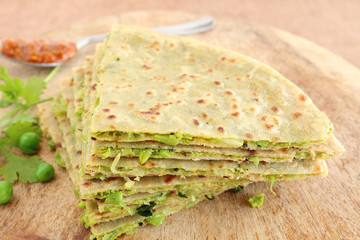 Indian food slices of paratha, which is a traditional and popular food native to north India, made from dough of wheat flour, cauliflower, and pea.