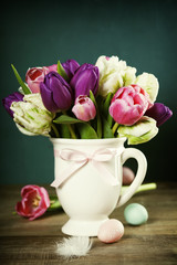 Beautiful tulips bouquet and easter eggs  on wooden table